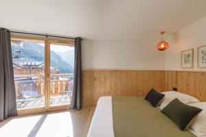 a bedroom with a bed and a large window at Bio Corti Spa 12 personnes in Champagny-en-Vanoise