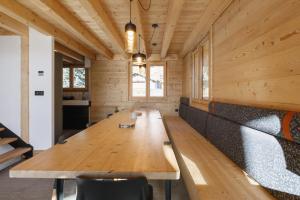 una gran mesa de madera en una habitación con paredes de madera en Bio Corti Spa 12 personnes, en Champagny-en-Vanoise