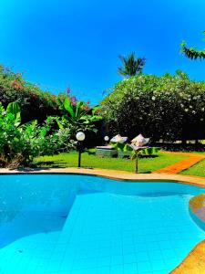 una piscina en un patio con árboles y arbustos en Villa Nova POOL own compound 8min walk to the beach Diani Beach, en Ukunda