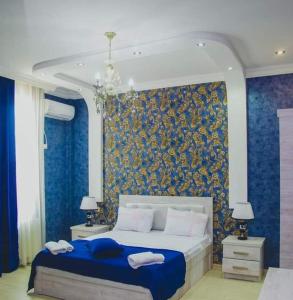 - une chambre avec un grand lit et un mur bleu dans l'établissement Лотус, à Zugdidi