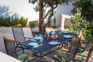 een blauwe tafel met stoelen en wijnglazen erop bij Villa Sky in Primošten
