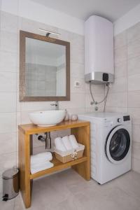 een badkamer met een wasmachine en een wastafel bij Villa Sky in Primošten