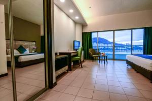 a hotel room with two beds and a desk with a table at Flamingo Hotel by the Beach, Penang in George Town +29 photos