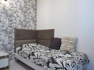 um quarto com uma cama com um cobertor preto e branco em Appartement Ardoines Shelter em Vitry-sur-Seine