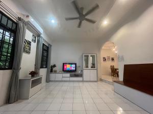 a living room with a ceiling fan and a tv at Joyful homestay Miri in Miri
