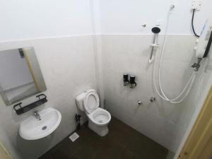 un baño con inodoro y lavabo en Rasyid Aideen Homestay, en Kijal
