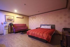 a bedroom with a red bed and a red chair at Shine Motel in Busan