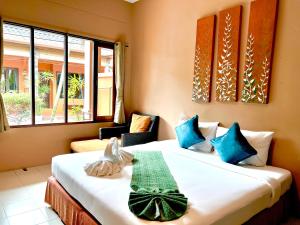 a bedroom with two beds with blue and green pillows at Phuket Siam Villas - SHA PLUS in Chalong