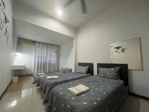 a bedroom with two beds and a mirror at Joyful homestay Miri in Miri