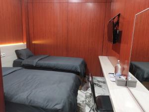 a small room with two beds and a tv at V Quin in Semarang