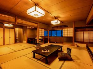 a room with a table and chairs in a room at Yukai Resort Premium Miyoshiya in Shinonsen