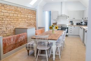 a kitchen with a wooden table and chairs at Butterwick - Barn Conversion with a hot tub on a Country Estate in Holbeck
