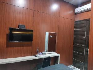 a bathroom with a mirror and a tv on a wooden wall at V Quin in Semarang