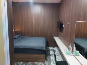 a small room with a bed and a mirror at V Quin in Semarang