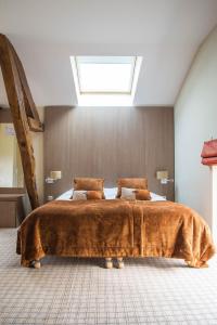 sypialnia z dużym łóżkiem i oknem dachowym w obiekcie Golf Hotel w mieście Saint-Saëns