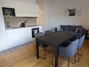 a living room with a black table and chairs at Refurbished 1BR Apartment in Limpertsberg in Luxembourg