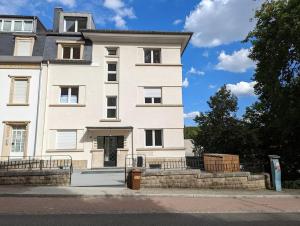 a large white building with a trash can in front of it at Refurbished 1BR Apartment in Limpertsberg in Luxembourg