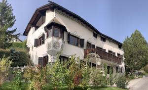 un grande edificio bianco con un tetto di Chasa Tusa Scuol a Scuol