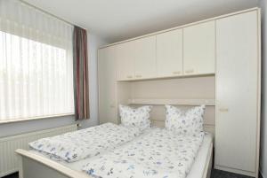 Un dormitorio con una cama con almohadas azules y blancas. en Ferienhaus Eilts, en Borkum