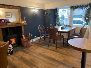 a dining room with a table and chairs and a fireplace at Coffee & Stays at Cartmel Square in Cartmel