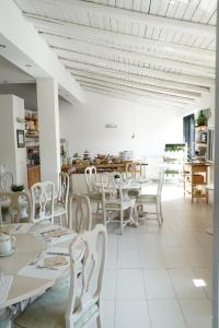 uma sala de jantar com mesas brancas e cadeiras brancas em Villa Michelangelo em Nicolosi