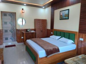 1 dormitorio con 1 cama grande con paneles de madera en Kaafal hotel & restaurant, en Dhanaulti