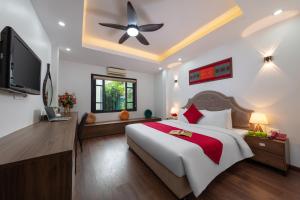 sypialnia z dużym łóżkiem i wentylatorem sufitowym w obiekcie Hanoi Liliane Hotel and Travel w mieście Hanoi