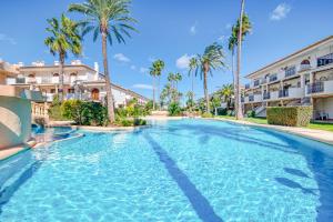 una piscina con palmeras en un complejo en Bahía Azul en Dénia