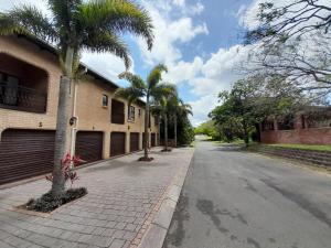 an empty street with palm trees and a building at Lake St Lucia Villas in St Lucia