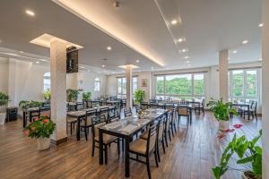 a dining room with tables and chairs and windows at Minh Chien Hotel in Da Lat