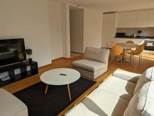 sala de estar con sofá y mesa en Stylish 2BR Apartment w/ Garage+Garden in Howald/Hesperange, en Hesperange