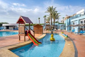 a swimming pool with a playground in a resort at Hotel Playas de Guardamar in Guardamar del Segura