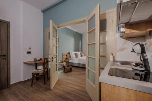 uma cozinha com um lavatório e um quarto com uma cama em Cathedral Suites em Heraclião