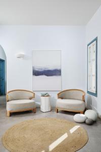 a living room with two chairs and a rug at Chrysalis Boutique - Adults Only in Astypalaia