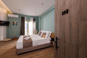 sypialnia z łóżkiem i drewnianymi drzwiami w obiekcie Cathedral Suites w Heraklionie