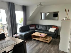 ein Wohnzimmer mit einem Sofa und einem Tisch in der Unterkunft Fewo Durak in Norderney
