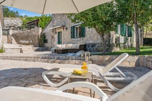a table with two chairs and an umbrella at Hacienda Sylvia - secluded 4-bedroom villa with 45sqm heated pool in Studenci
