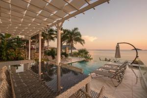 a swimming pool with a view of the ocean at BEACHFRONT WHITE VILLA WİTH PRIVATE SWIMMING POOL in Kalkan