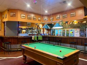 a pool table in a room with a bar at Main Reef Hotel in Boulder