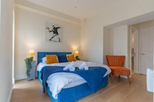 a bedroom with a blue bed and a chair at Modern & Classy 2 bedroom flat, Free Parking 