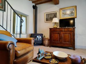 a living room with a couch and a television at The Monastery - St Antimo in Monterchi