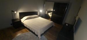 um quarto com uma cama branca e um espelho em Aпартамент за гости Mари em Kyustendil