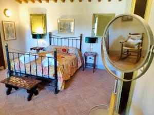 een slaapkamer met een bed en een spiegel bij The Monastery - St Antimo in Monterchi