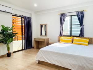 Un dormitorio con una cama con almohadas amarillas y una ventana en GP House Bangkok - Sukhumvit Onnut BTS Skytrain, en Bangkok
