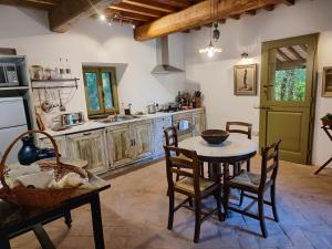 a kitchen with a table and chairs in a room at The Monastery - St Antimo in Monterchi