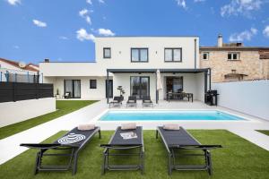 een villa met een zwembad en een huis bij Villa Artis by IstriaLux in Loborika