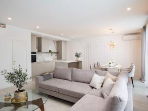 uma sala de estar com um sofá cinzento e uma cozinha em Villa Artis by IstriaLux em Loborika