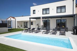 a villa with a swimming pool in front of a house at Villa Artis by IstriaLux in Loborika
