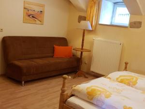 ein Wohnzimmer mit einem Sofa und einem Bett in der Unterkunft Ferienwohnung Ahrens in Ehrenberg