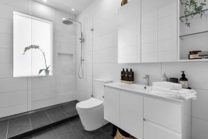 a white bathroom with a toilet and a sink at Bev's Retreat by Ready Set Stay in Melbourne